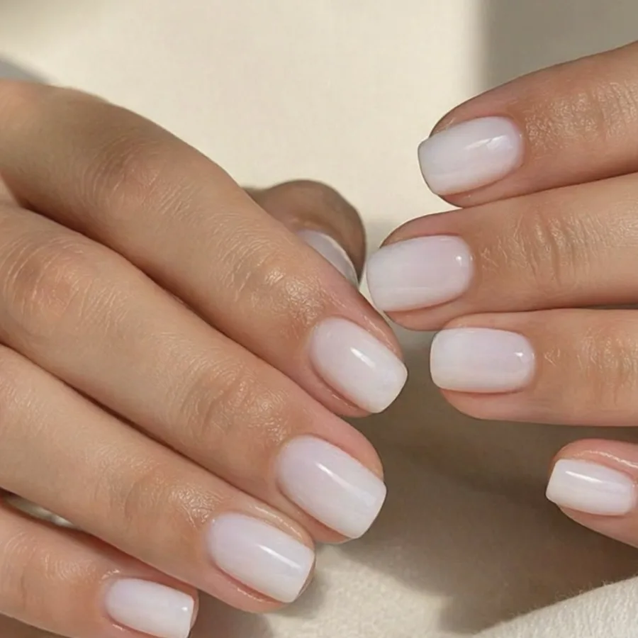 Pose blanc laiteux sur des ongles carrés courts