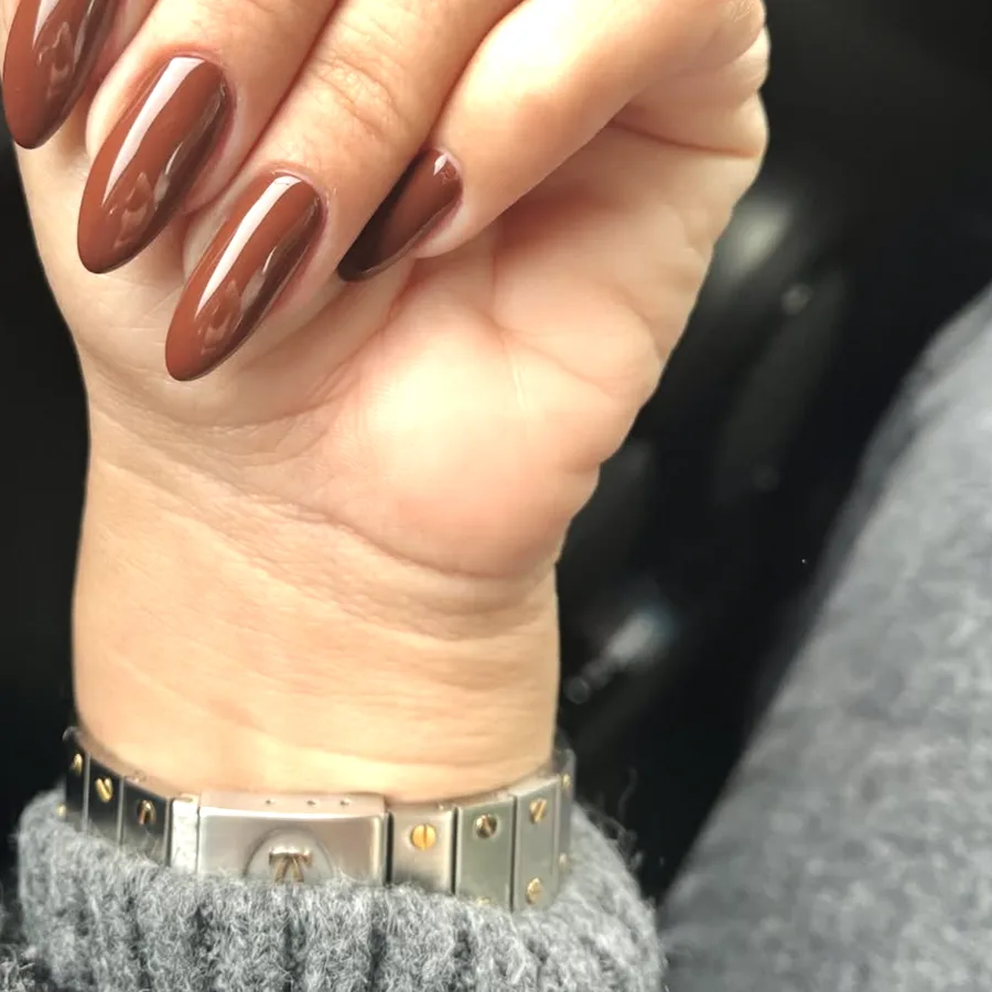 Pose brun chocolat sur des ongles en amande